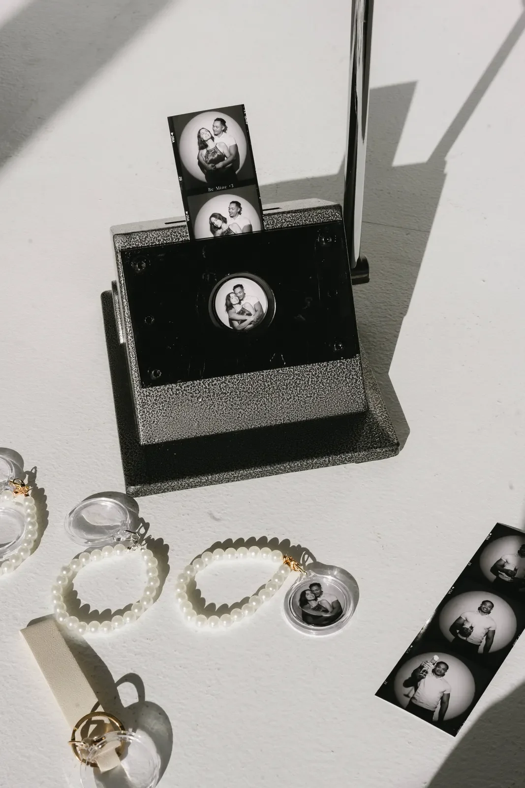 Pearls and photo strips styled beside a vintage booth camera