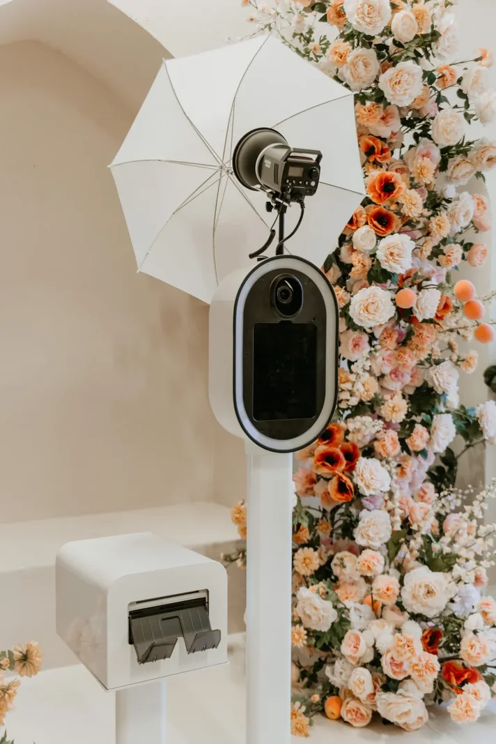 The booth beside a flower wall at a beachfront wedding